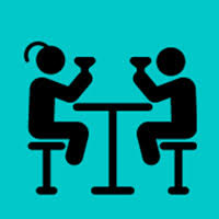 two patrons at a table raising a glass